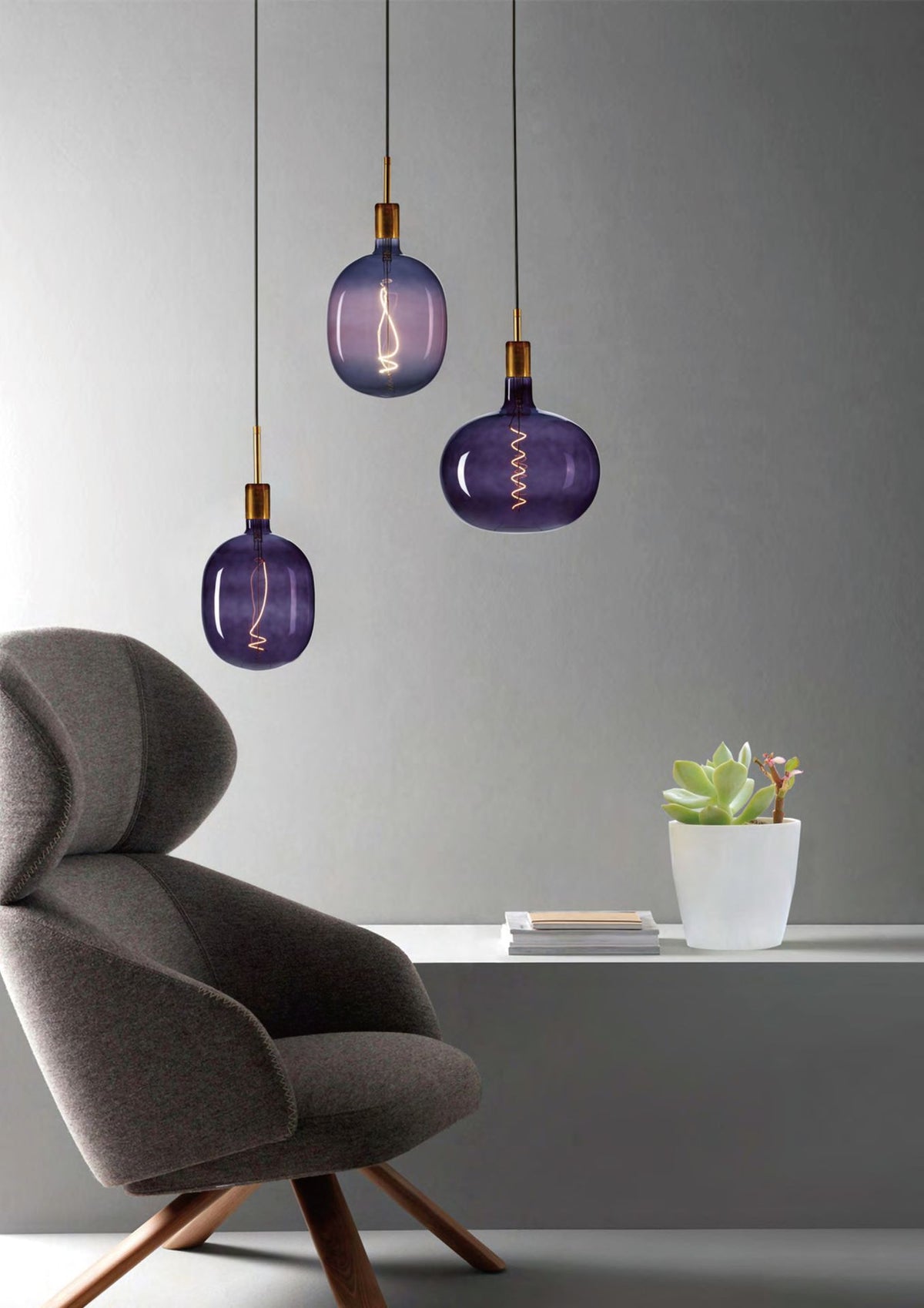 Kavics formájú dekor LED izzók függesztékekben modern nappaliban, fotel felett